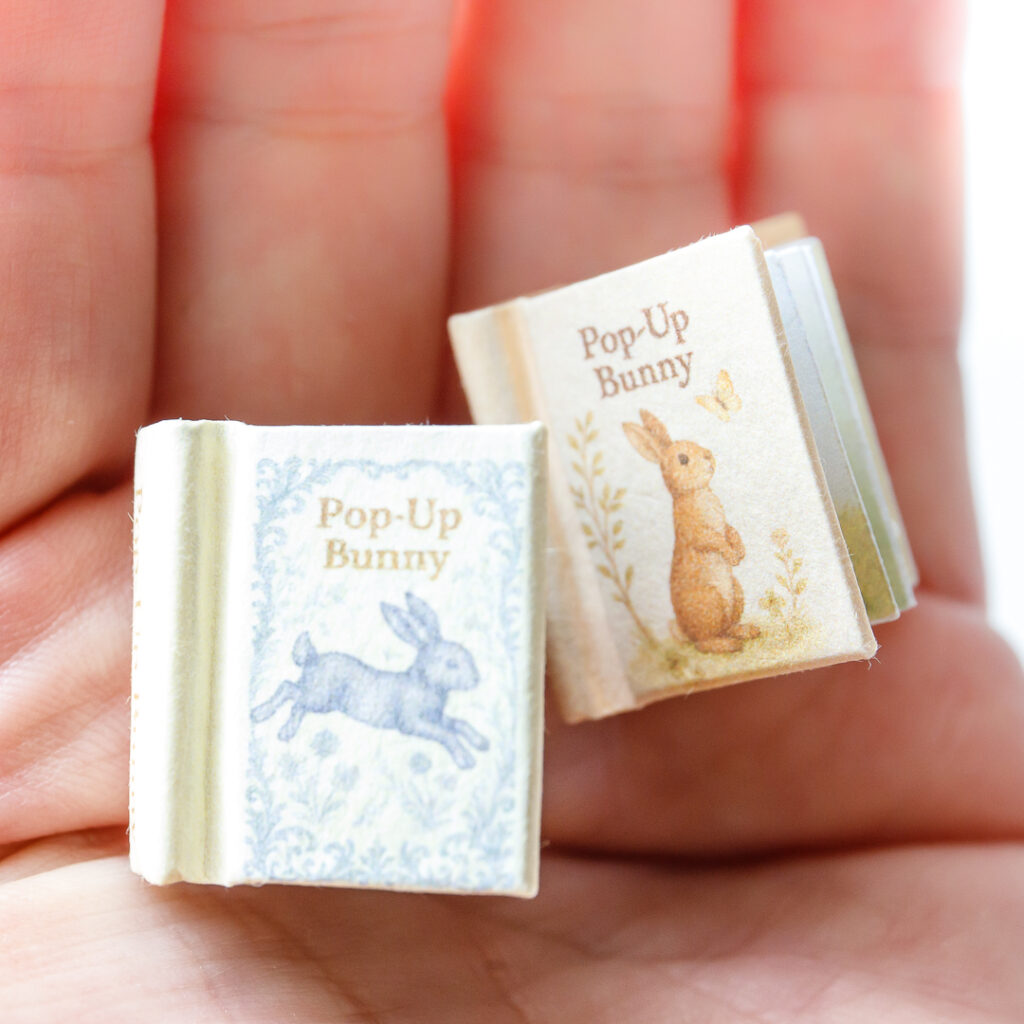 手のひら載せた2.5ｃｍサイズのうさぎの飛び出す絵本 二種